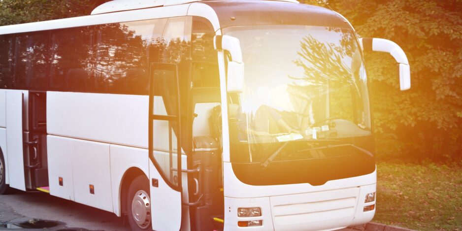 White tourist bus for excursions. The bus is parked in a parking lot near the park
